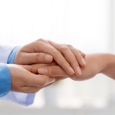Doctor holding patient's hands, representing communication and transparency in healthcare