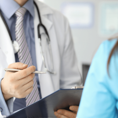 Cropped photo of doctor talking to a patient, representing risk management in medical practice