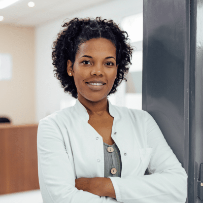 Female medical professional standing by a door with her arms crossed, representing starting your own private practice
