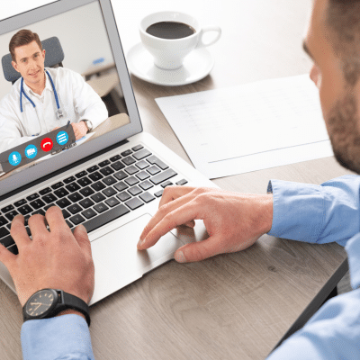 A man using a laptop for telemedicine, representing technology in private practice