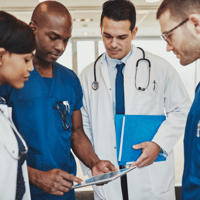 A group of medical professionals looking at a tablet, representing private practice challenges