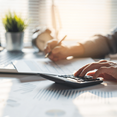 Calculating finances with documents and calculator, representing financial statements for medical practices